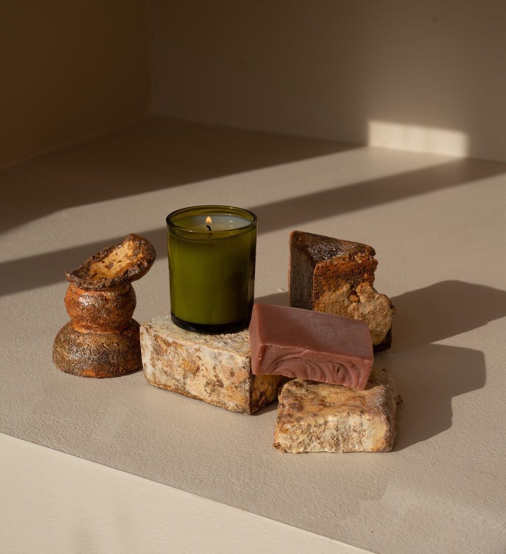 A lit candle standing in a grown mycelium holder