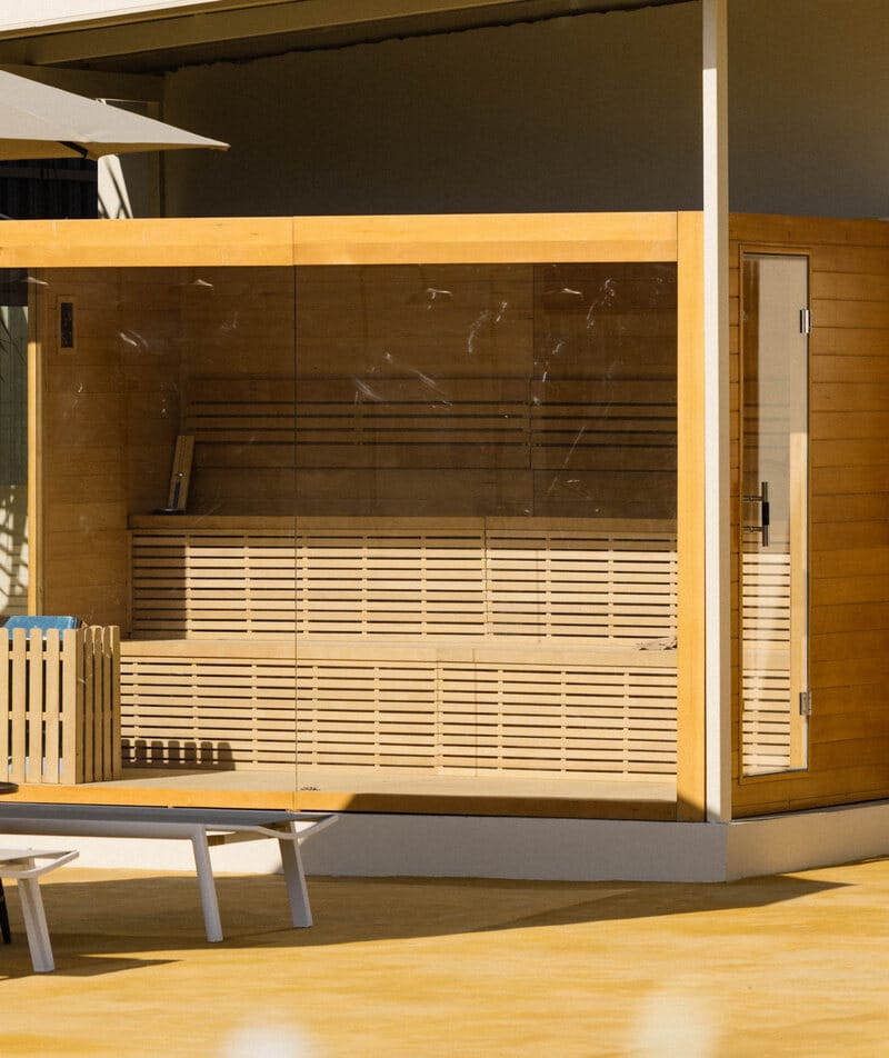 The glass-fronted sauna cabin and its slatted wooden benches